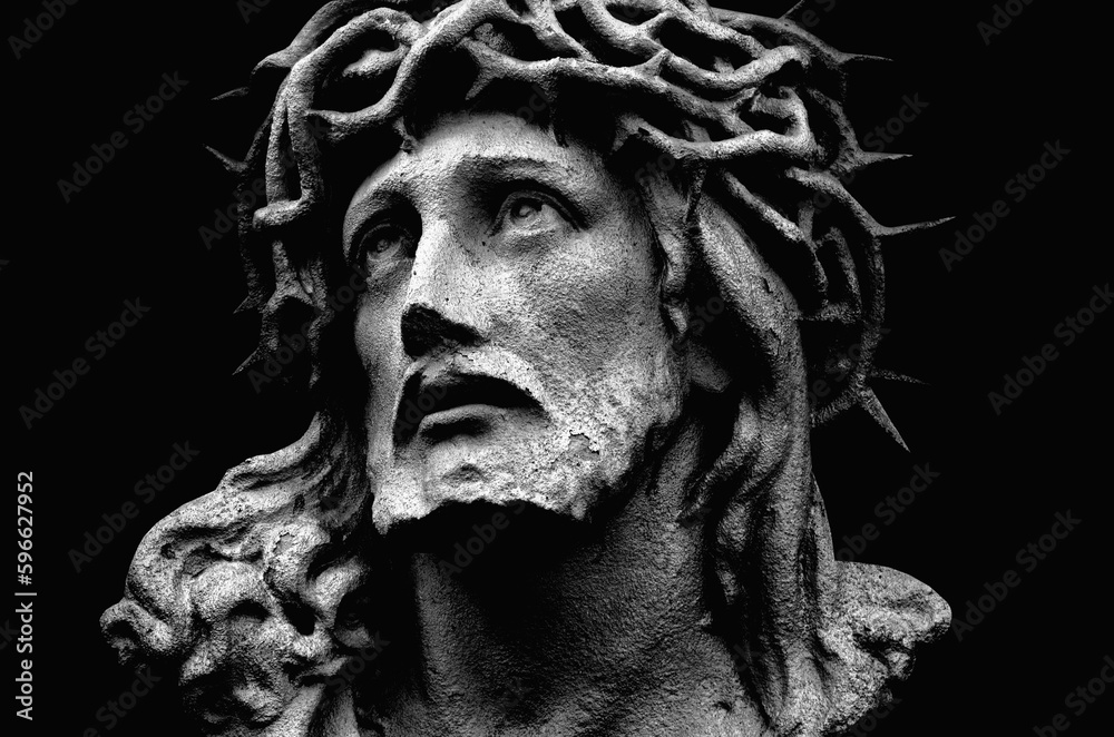 Antique statue of Jesus Christ crown of thorns against black background. Horizontal image.