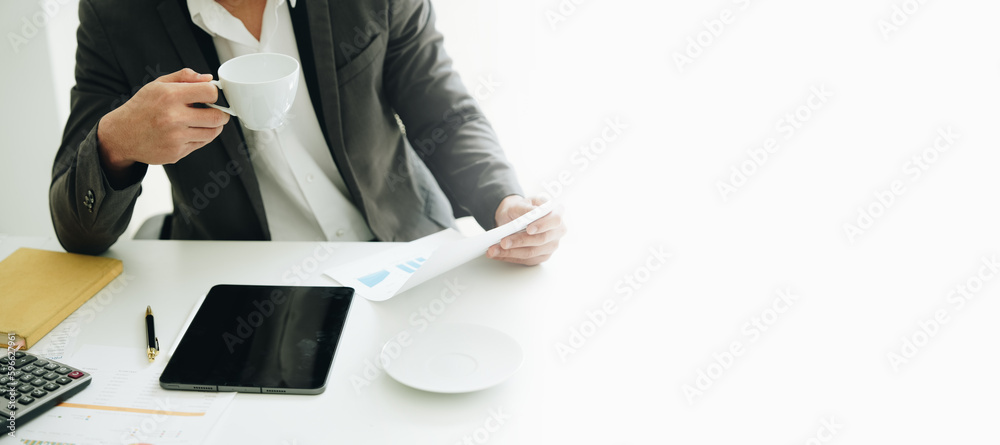 Portrait of a young Asian woman showing a smiling face as she uses his phone, computer and financial documents on her desk in the early morning hours Portrait of a young Asian woman showing a smiling face as she uses his phone, computer and financial documents on her desk in the early morning hours