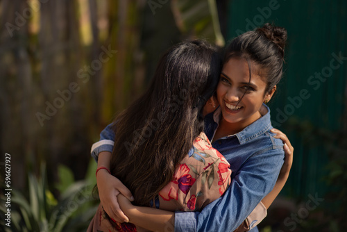 Two smiling young women embracing each other