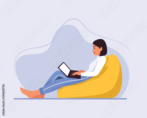 light-skinned girl with short hair sits on a bean bag chair with a laptop