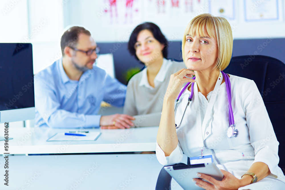 Doctor woman sitting with male patient at the desk. Doctor woman sitting with male patient at the desk.