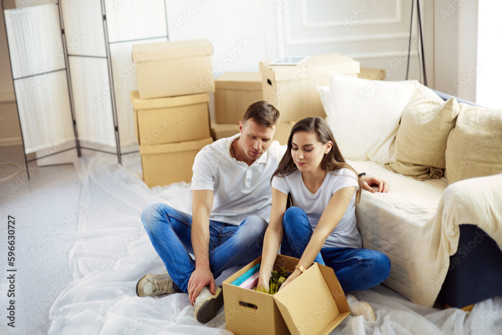 Happy young couple unpacking or packing boxes and moving into a new home. Happy young couple unpacking or packing boxes and moving into a new home.