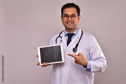 Young Indian Male Doctor showing blank screen of digital tablet