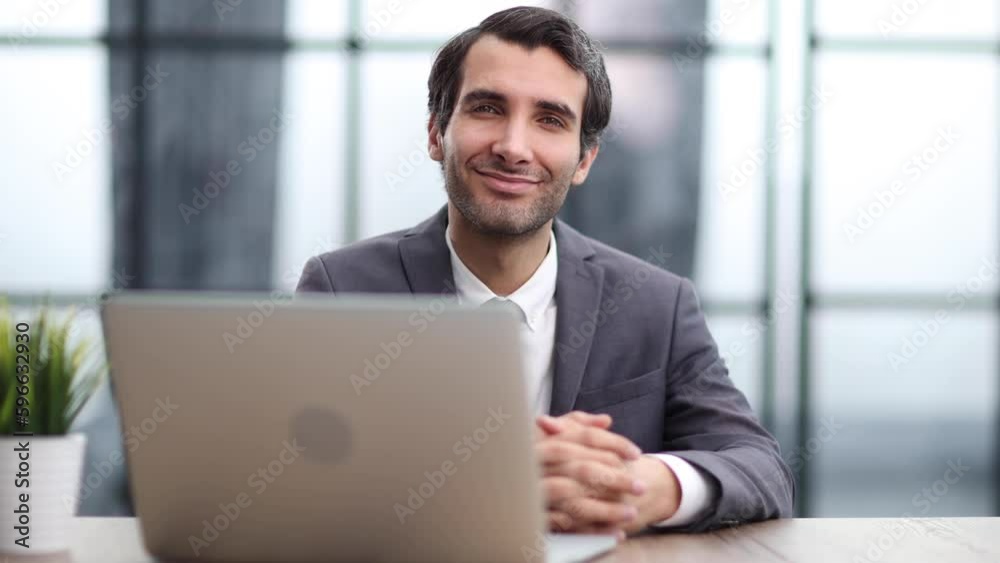 Smiling business man working on laptop at office. Smiling business man working on laptop at office.