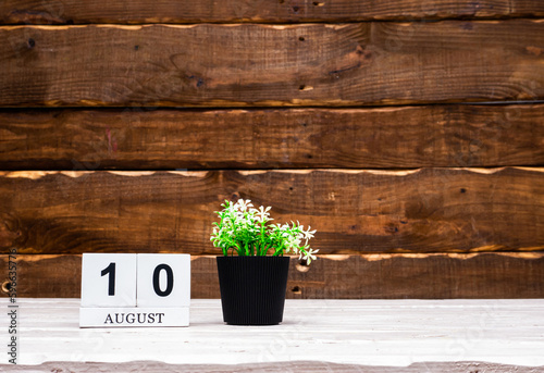 August calendar with number  10. Planner copy space on a wooden brown background. March number icon. Place for text background calendar photo