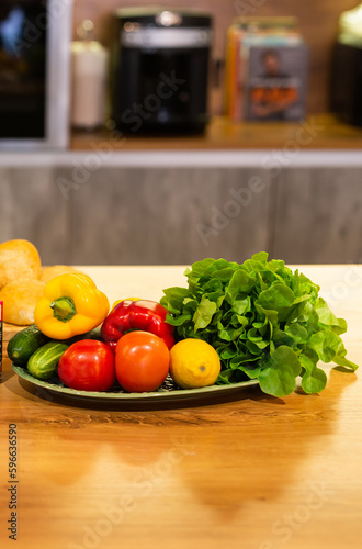 Still life of fresh organic vegetables on plate on kitchen - vegetarian and vegan concept.