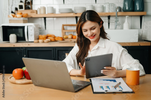 Business woman using tablet and laptop for doing math finance on an office desk, tax, report, accounting, statistics, and analytical research concept in office