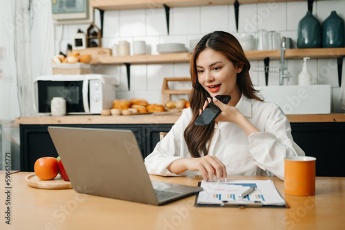 Happy asian business woman have the joy of talking on the smartphone, tablet and laptopon the modern office