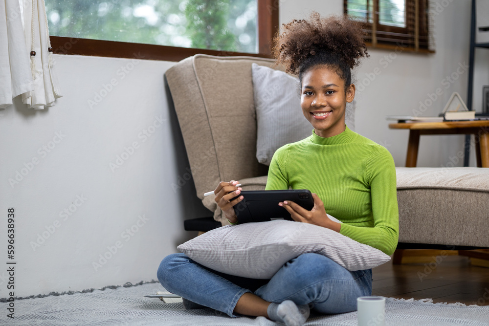 An American teenage woman is in the living room, she is spending her weekends at home playing social media and watching movies. The concept of living on vacation. An American teenage woman is in the living room, she is spending her weekends at home playing social media and watching movies. The concept of living on vacation.
