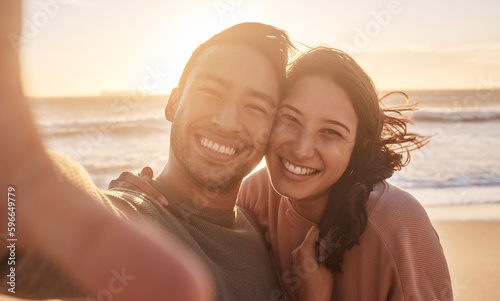 Portrait of a young diverse biracial couple taking a selfie at the beach and having fun outside. Portrait of a young diverse biracial couple taking a selfie at the beach and having fun outside. © Oostendorp/peopleimages.com