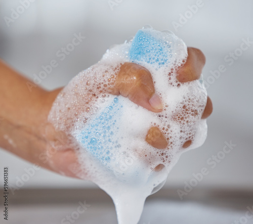 Ready to wash through dirt and grime with a soapy sponge. Closeup shot of an unrecognisable woman squeezing soap from a sponge at home.