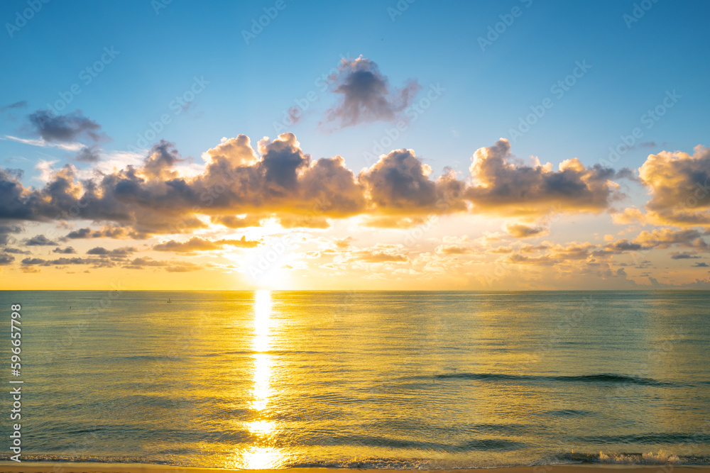 Sunset on sea. Ocean beach sunrise with calm cloudy sky.