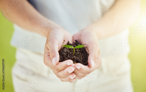 Its growing. Cropped shot of a man holding a plant growing out of soil.