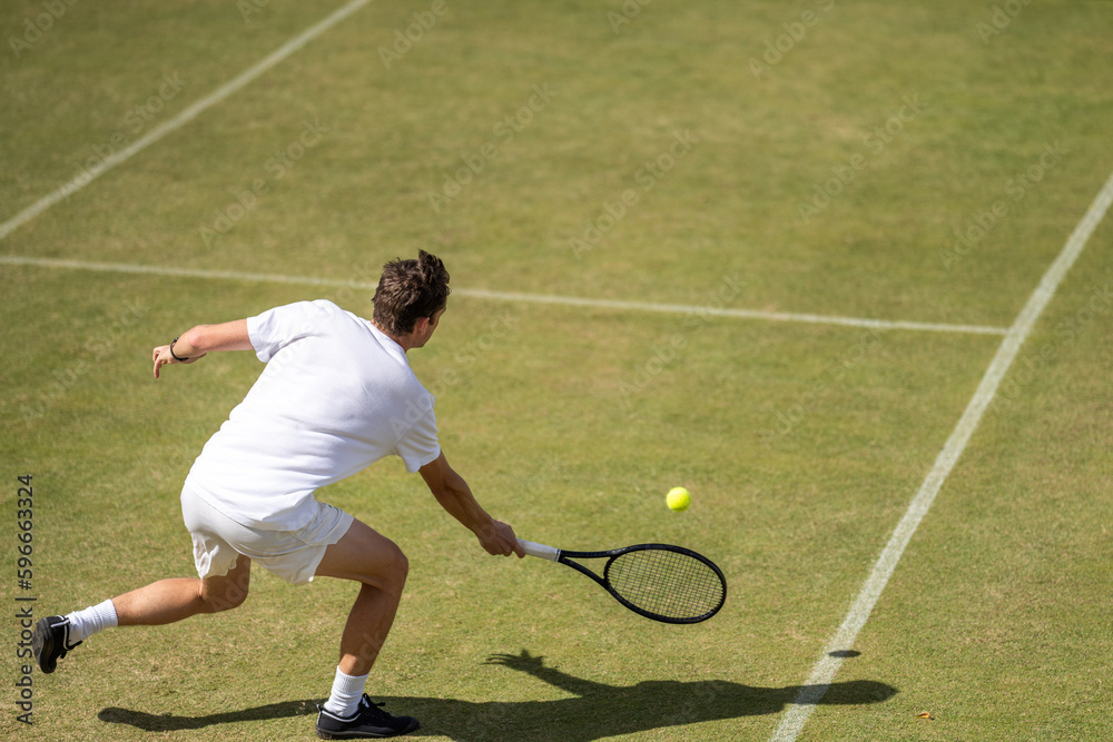 Amateur playing tennis at a tournament and match on grass in Europe 