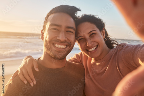 Принти на полотні Portrait of a young diverse biracial couple taking a selfie at the beach and having fun outside