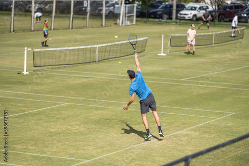 Amateur playing tennis at a tournament and match on grass in Europe  © William