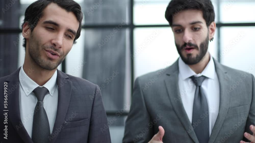 Two businessmen talking and walking down office corridor Two businessmen talking and walking down office corridor