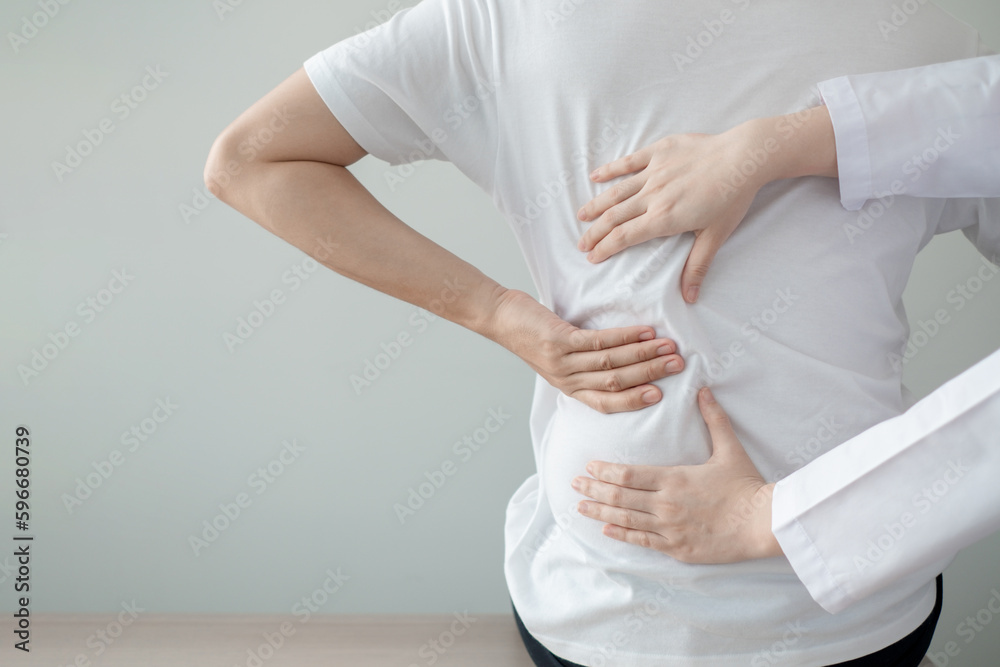 Therapist treating injured back of male patient. Therapist treating injured back of male patient.