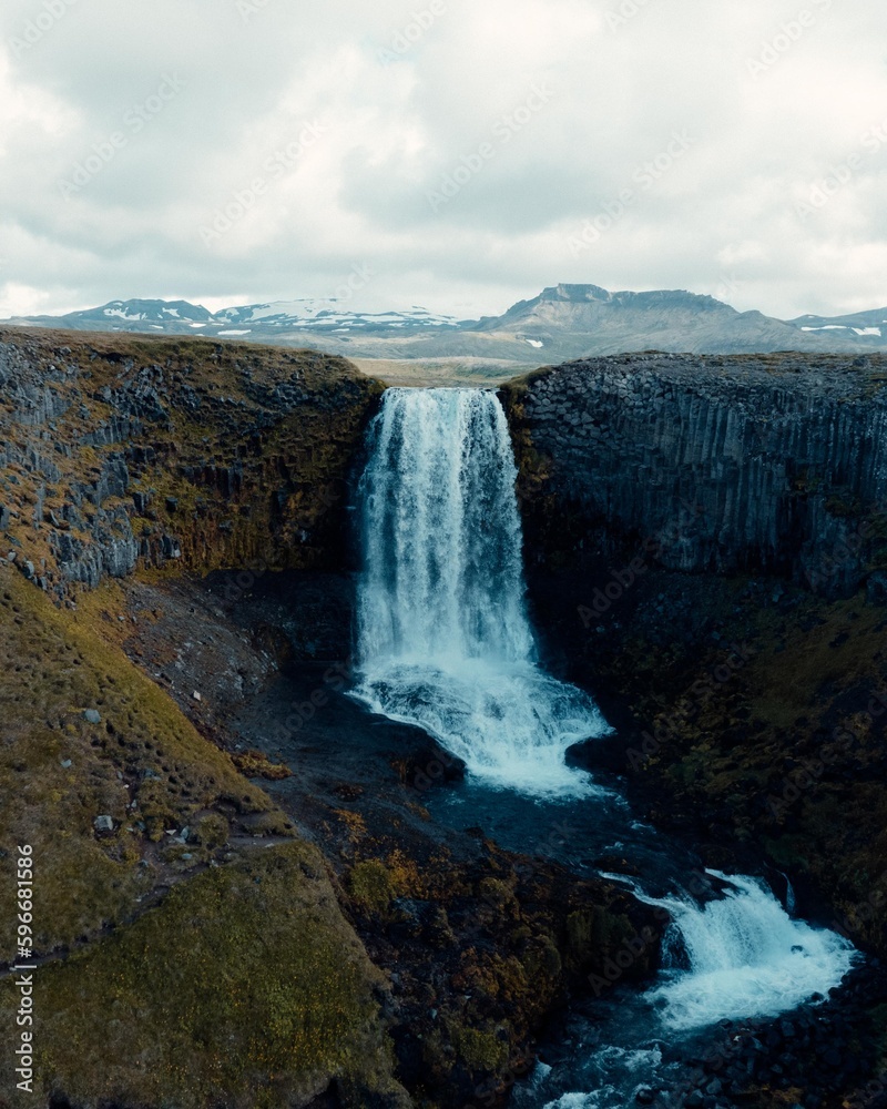 Drone Aerial of Kerlingarfoss Waterfall near Olafsvik on Iceland's Snafellsnes peninsula. High quality photo. Beautiful waterfall with the Snaefellsjokull Volcano in the background.