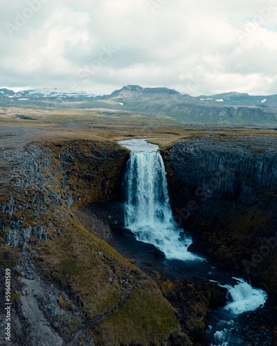 Drone Aerial of Kerlingarfoss Waterfall near Olafsvik on Iceland's Snafellsnes peninsula. High quality photo. Beautiful waterfall with the Snaefellsjokull Volcano in the background.