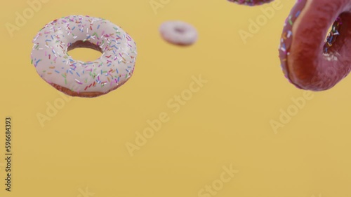 Donuts falling in slow motion. Yellow background. CInematic.