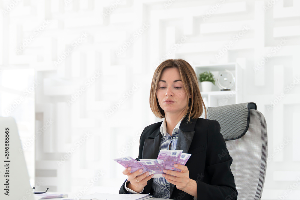 Arrogant and confident business woman holding much money sitting in her office and demonstrating her love to cash Arrogant and confident business woman holding much money sitting in her office and demonstrating her love to cash