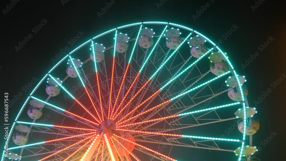 A big festive colorful ferris wheel at night against the background of the night sky. Ferris wheel at night of colorful with outdoor round rotation st Amusement Park, The annual temple event has A big festive colorful ferris wheel at night against the background of the night sky. Ferris wheel at night of colorful with outdoor round rotation st Amusement Park, The annual temple event has