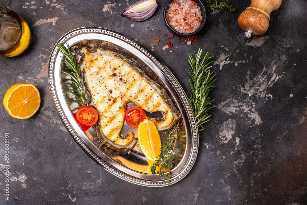 fish steak grill Atlantic wolffish, seawolf or catfish steak, on a dark background, top view