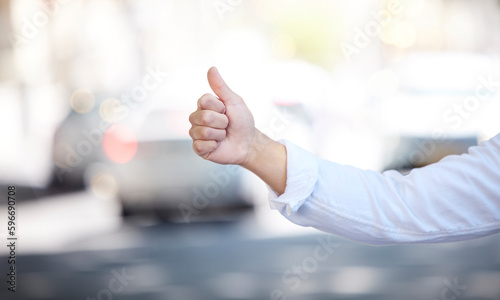 I hope this oncoming taxi stops for me. Closeup shot of an unrecognisable businesswoman showing thumbs up while gesturing for a cab in the city.