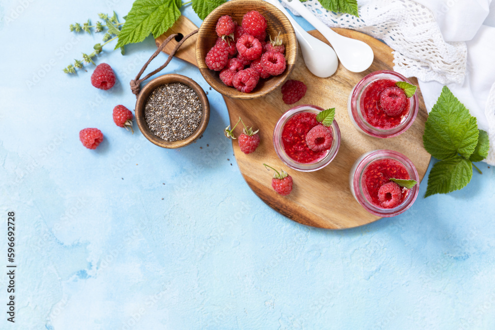 Chia seed pudding with raspberry and jam or smoothies with chia seeds on a stone table. Healthy breakfast. View from above. Copy space. Chia seed pudding with raspberry and jam or smoothies with chia seeds on a stone table. Healthy breakfast. View from above. Copy space.