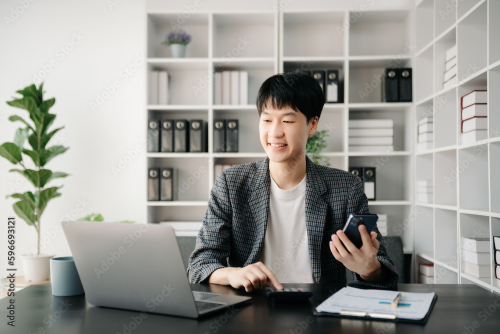 Portrait of young man sitting at his desk in the office Portrait of young man sitting at his desk in the office