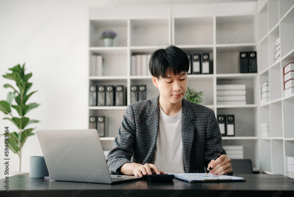 Portrait of young man sitting at his desk in the office Portrait of young man sitting at his desk in the office