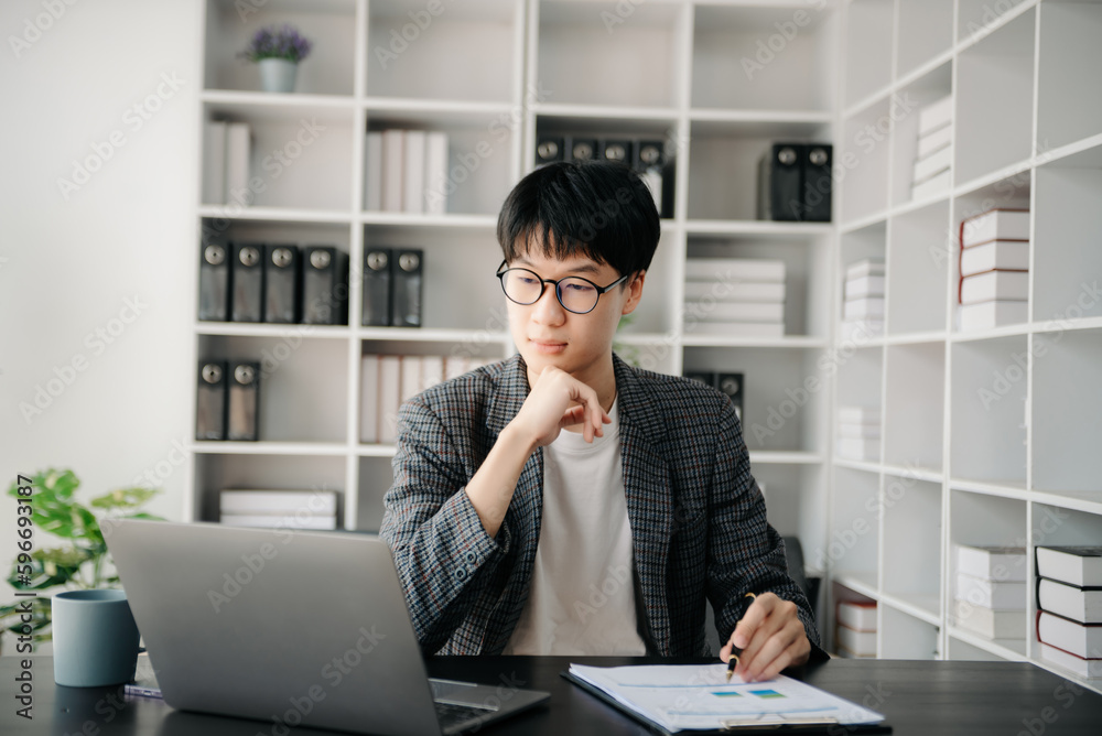 Portrait of young man sitting at his desk in the office Portrait of young man sitting at his desk in the office