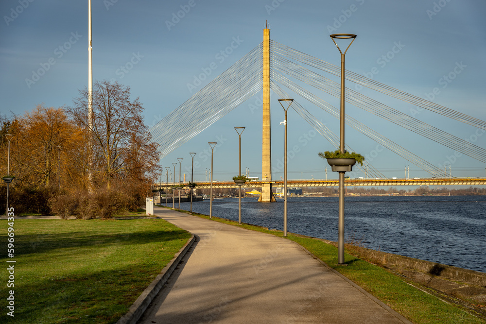 Riga, Latvia - Footpath along the Daugava river with Vansu Bridge in the background