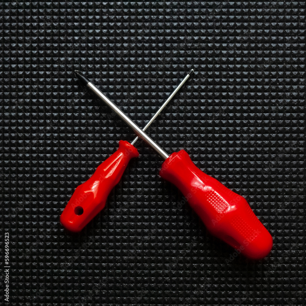 Red screwdrivers on black background Red screwdrivers on black background