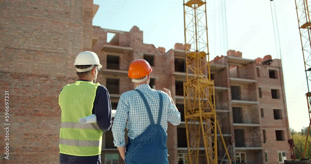 Engineer and worker looking at notepad at construction Engineer and worker looking at notepad at construction