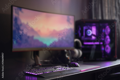 Modern gaming desktop setup, RGB lights, widescreen monitor and water cooling. Purple background