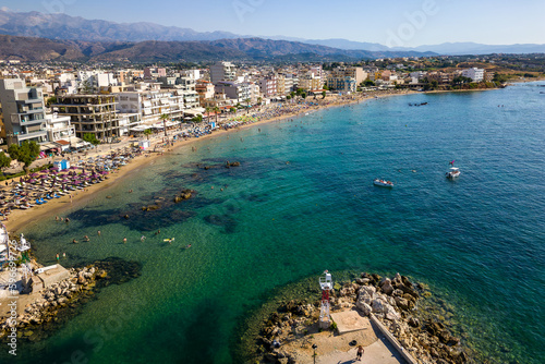 Fototapeta Naklejka Na Ścianę i Meble -  Aerial view of a busy beach in the popular resort town of Nea Chora in Chania, Crete (Greece)
