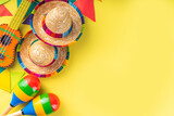 Mexican Cinco de Mayo holiday background with mexican cactus,guitars, sombrero hat, maracas, Bright yellow flat lay with traditional Cinco de Mayo decor and party accessories