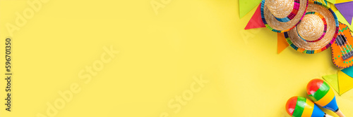 Mexican Cinco de Mayo holiday background with mexican cactus,guitars, sombrero hat, maracas, Bright yellow flat lay with traditional Cinco de Mayo decor and party accessories