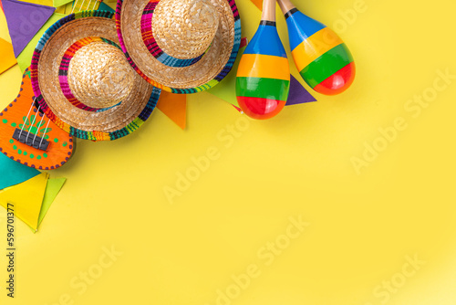 Mexican Cinco de Mayo holiday background with mexican cactus guitars  sombrero hat  maracas  Bright yellow flat lay with traditional Cinco de Mayo decor and party accessories