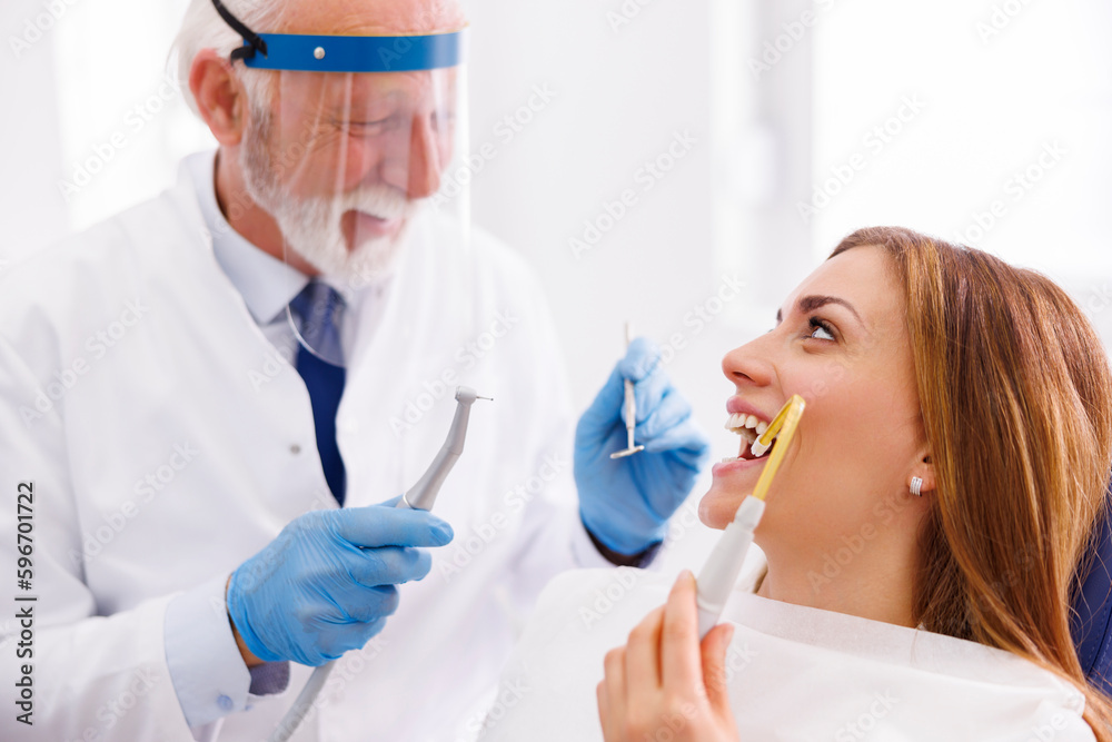 Doctor fixing patient tooth at dentist office Doctor fixing patient tooth at dentist office