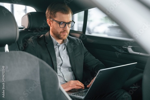 Man in formal business clothes is sitting in the modern automobile © standret