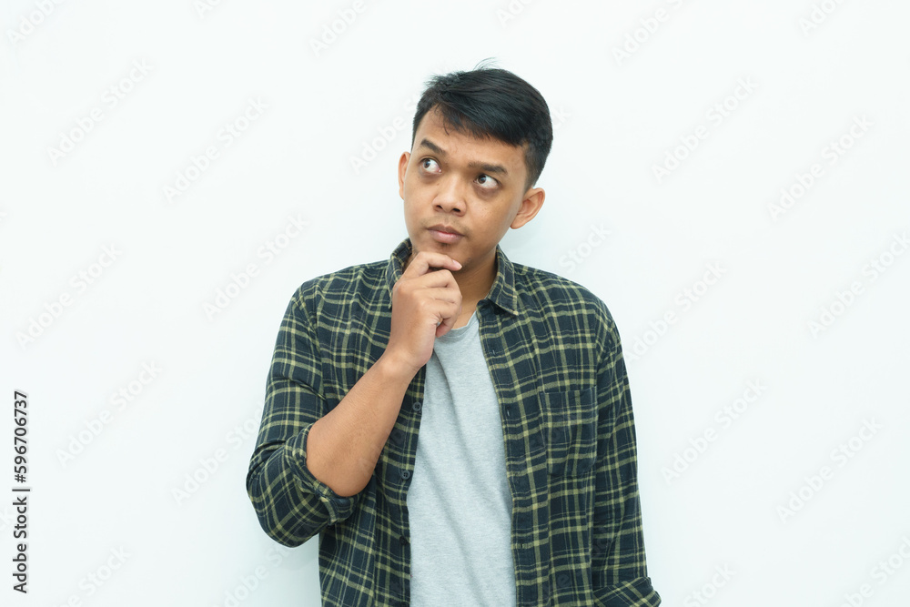 Young Asian man smiling put the fingers on the chin for thinking gesture Young Asian man smiling put the fingers on the chin for thinking gesture