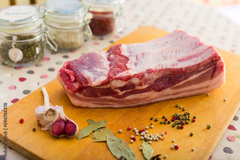 fresh piece of pork belly on wooden board with spices fresh piece of pork belly on wooden board with spices