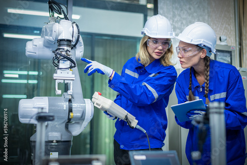 Engineer factory industry wearing safety uniform work and checking system of the welding robots for welding steel electrical by control system robot automate for industry manufacture concept.