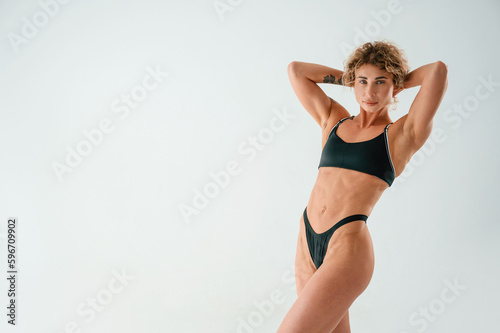 Beautiful abs. Young caucasian woman with athletic body shape is indoors at daytime