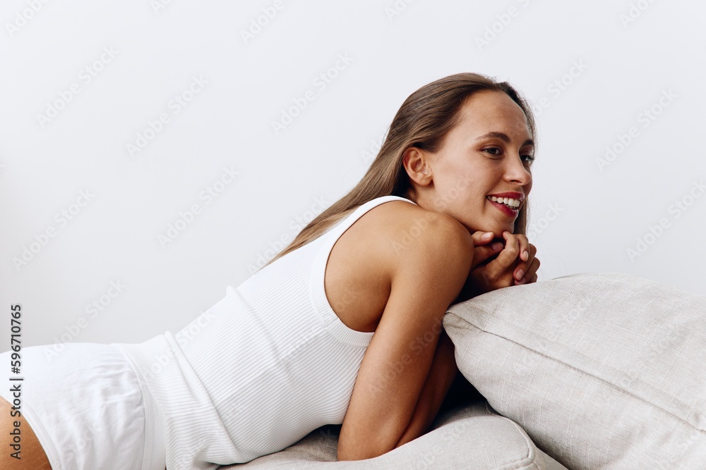 Beautiful woman model poses lying on pillows on the floor with tanned skin caring for her body, beauty treatments at home, a beautiful healthy body Beautiful woman model poses lying on pillows on the floor with tanned skin caring for her body, beauty treatments at home, a beautiful healthy body