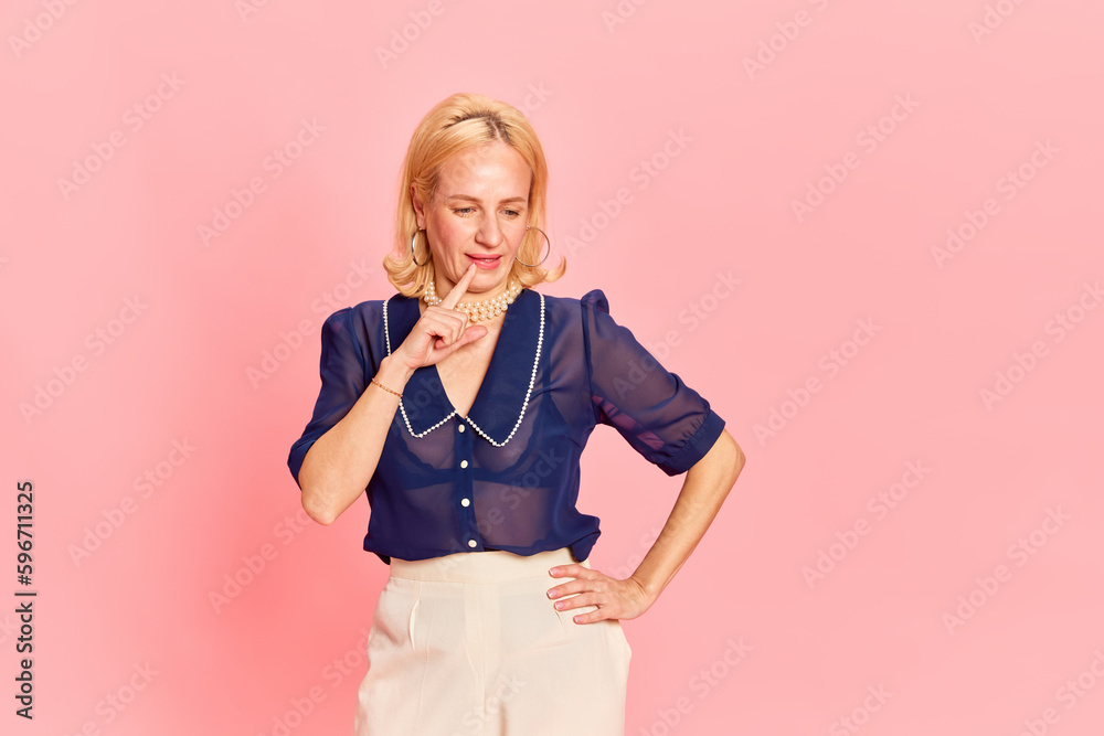 One attractive blond woman wearing fancy retro costume in process of creating good ideas over pink studio background. Creative One attractive blond woman wearing fancy retro costume in process of creating good ideas over pink studio background. Creative