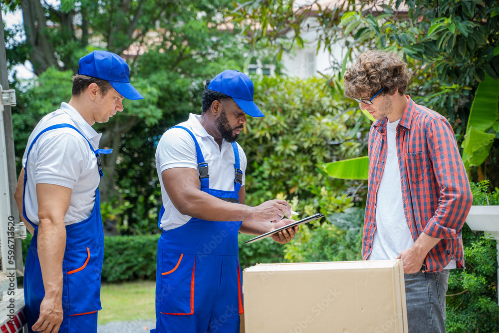 Moving service workers unloading boxes and checking list,Receives and signs on clipboard. Moving service workers unloading boxes and checking list,Receives and signs on clipboard.